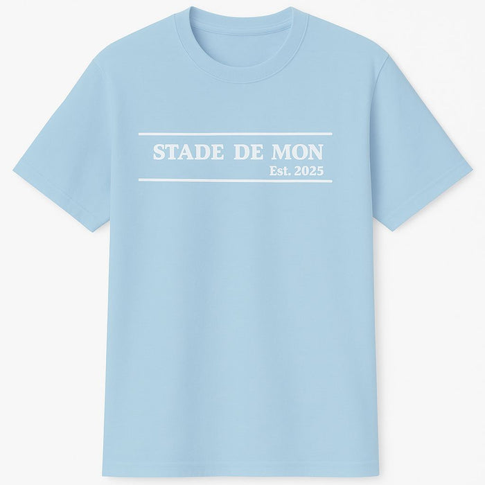 Light blue t-shirt with 'STADE DE MON Est. 2025' text on a white background